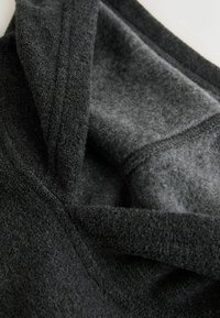 Sort blød stof med en struktureret overflade og glat, grå fleecefor. Stoffet fremstår tykt og varmt, velegnet til overtøj.