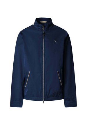 Marineblauw jack met ritssluiting en opstaande kraag, twee voorzakken met beige bies en een klein wit logo van gekruiste golfclubs op de borst.