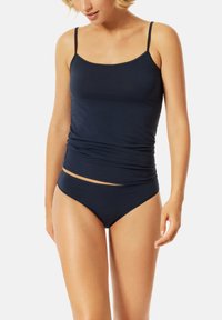 Dunkelblaues Trägershirt mit dünnen Trägern und tailliertem Design, kombiniert mit passenden Bikini-ähnlichen Slips, die eine glatte Textur und kein Muster aufweisen.