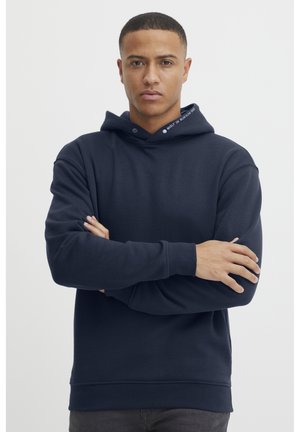 Felpa blu navy con vestibilità comoda, realizzata in tessuto morbido. Presenta un cappuccio con cordino, polsini e vita a costine, con una texture liscia.