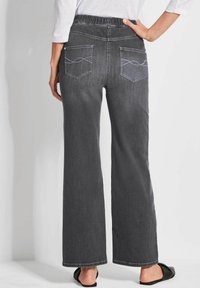 Jean large gris avec une taille élastique, comportant deux poches au dos et un surpiquage décoratif. Texture de denim lisse, avec un ourlet soigné.