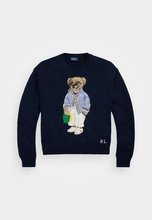 Pull tricoté bleu marine avec un ours brodé portant des lunettes de soleil, veste rayée, pantalon blanc, tenant un objet vert et jaune, avec les initiales "RL" à l'ourlet.