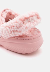 Roosa libisemise takistusega king, millel on paks ja pehme karvane vooder ning rihm, näidates pehmet tekstuuri ja kummist talla valgel taustal.