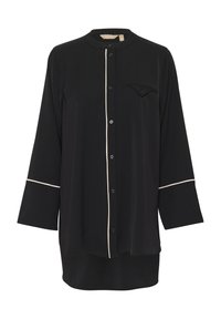 Melnā krekla ar garām piedurknēm, ar apaļu apkakli, baltu apdari pa priekšu un piedurknēm, kā arī vienu krūšu kabatu, izgatavots no viegla auduma.