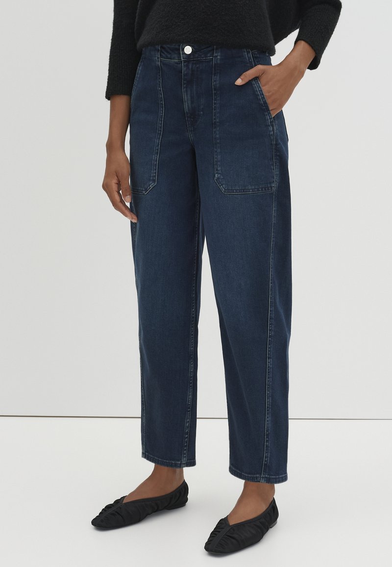 Pantaloni in denim blu scuro a vita alta con gamba dritta, caratterizzati da ampie tasche frontali e dettagli di cucitura sottili.