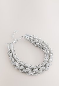 Silver braided bracelet featuring textured strands with metallic accents and a clasp closure. The design is embellished with small reflective beads.