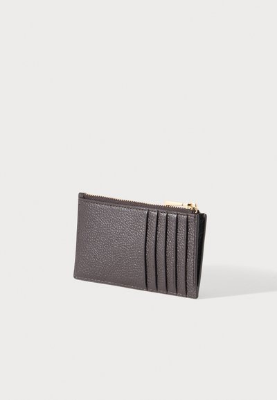 Porte-cartes en cuir texturé gris foncé avec cinq emplacements pour cartes et une fermeture éclair dorée en haut, photographié sur un fond clair uni.