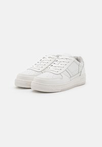 Vita lädersneakers med en slät yta, rund tå, perforerade detaljer och strukturerad gummisula. Klassisk snörningsdesign.