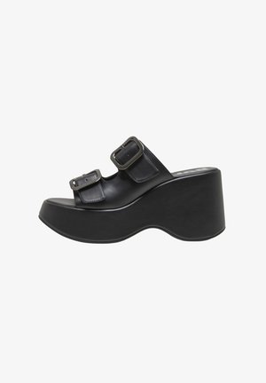 Sort platformsandal med tyk sål, to brede remme med store metalspænder og et buet hældesign.