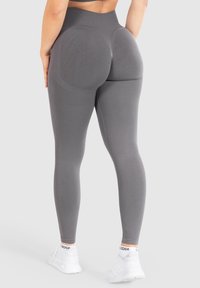 Grijze high-waisted leggings met een gladde, rekbare stof, een aansluitend ontwerp en ribbelaccenten op de tailleband en dijen.