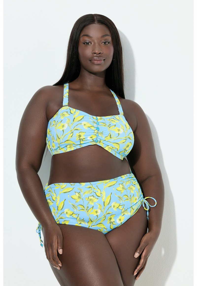 Bikini-setti, jossa on kukkakuosi keltaisena vaaleansinisellä taustalla. Yläosa on säädettävillä olkaimilla, keskitetyllä ryppytyksellä ja nappikoristeilla.