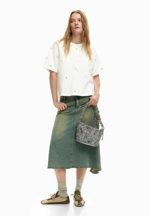 Valge lühikese lõikega t-särk lillemustriga, sinine teksaseelik, hall trükitud käekott ja oliivrohelised tossud tekstuurse põhjaga, stiilselt triibuliste sokkidega.