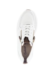 Sneaker bianco in materiale di pelle, punta rotonda, parte superiore texturizzata, dettaglio con zip dorata di lato e un accento marrone sul tallone.