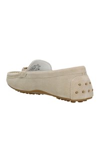 Bežové z semišové slip-on boty s kulatou špičkou, ozdobným prošíváním a gumovou podrážkou se znaky malých vyvýšených teček na zadní části pro lepší přilnavost.