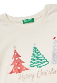 Cremfarbener Baumwoll-T-Shirt mit drei dekorativen Christbäumen in rot, grün und silbernem Glitzer, mit dem Text "Frohe Weihnachten" darunter.
