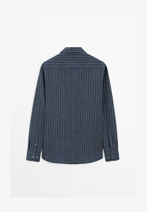 Tmavě modrá košile s dlouhým rukávem s tenkými bílými svislými pruhy, zapnuté manžety a špičatý límec, zobrazená zezadu.