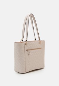 Gequilte beige shopper met dubbele handgrepen, goudkleurige hardware en een voorvak met rits. Glad materiaal met een gestructureerde vorm en een diamantpatroon.