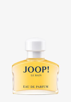 Joop! Le Bain Eau de Parfum in einer klaren Glasflasche mit abgerundeten Schultern, gefüllt mit bernsteinfarbener Flüssigkeit und einem weißen Verschluss.