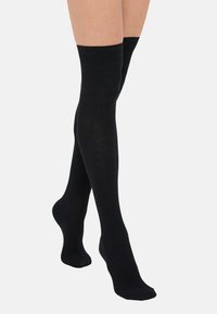 Čierne podkolienky s ribbovanou textúrou, vyrobené z jemného materiálu, s vystuženou špičkou a manžetou pre vyššiu odolnosť.