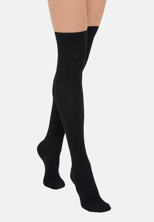 Juodos iki kelių kojinės su briaunotu tekstūru, pagamintos iš minkštos medžiagos, su papildomai sustiprintu pirštu ir kraštu, kad būtų užtikrintas didesnis tvirtumas.