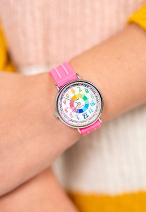 Montre d'enfants colorée avec un cadran rond, un cadran blanc, des marqueurs d'heure en arc-en-ciel et un bracelet en silicone rose. Accents en matériel argenté.