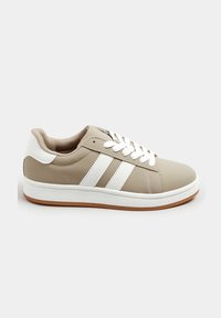 Beżowe sneakersy z białymi akcentami, z trzema białymi paskami, wyściełanym kołnierzem, sznurowanym przodem i teksturowaną gumową podeszwą.