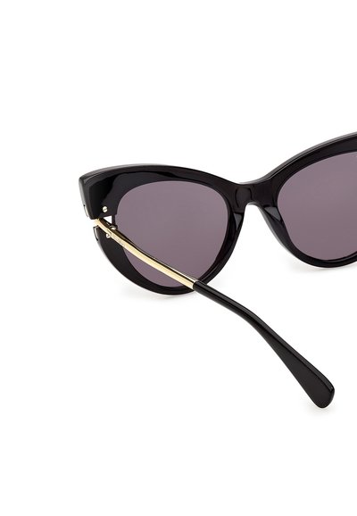 Schwarze Cat-Eye-Sonnenbrille mit dunklen Gläsern und goldakzentuierten Bügeln, schräg vor weißem Hintergrund dargestellt.