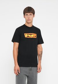 Black cotton t-shirt featuring a bold red and yellow graphic logo on the front. Short sleeves and a classic crew neck design.