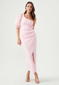 Pink dress with one shoulder and puff sleeve in sheer polka dot fabric. Fitted design with a side slit, made from textured material.