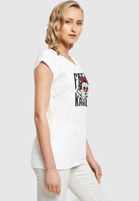 Hvid bomulds t-shirt med korte ærmer, med et farverigt kraniegrafik og teksten "FRENI KAHLO" trykt på foran.