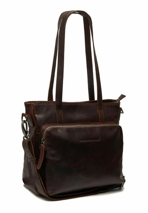 Sac fourre-tout en cuir marron avec deux longues poignées. Comprend une poche zipée à l'avant et des coutures contrastées. Texture lisse avec un design sobre.