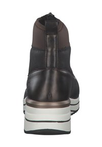 Bottine en cuir marron avec un haut en tissu élastique, semelle blanche, talon renforcé et finition lisse. Comprend une boucle pour un enfilage facile.