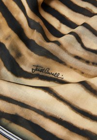 Mintás textil sál váltakozó fekete csíkokkal világosbarna háttérrel, sima textúrával és egy alig észlelhető aláírás mintázattal.
