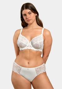Soutien-gorge en dentelle blanche avec des motifs floraux, support par armatures et bretelles réglables, associé à un slip en dentelle taille haute assorti.