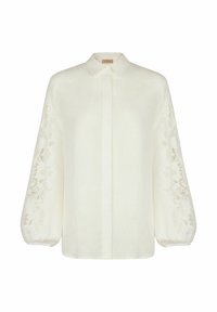Hvid linnedbluse med lange, puffede ærmer, der har intrikate blomstermotiver broderet. Krave med knaplukning foran, afslappet pasform.