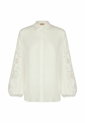 Weiße Leinenbluse mit langen, puffigen Ärmeln und aufwendiger Blumenstickerei. Mit Kragen, Knöpfen vorne und lockerem Schnitt.
