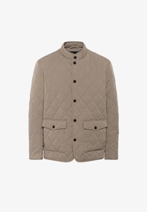 Kangastatud beež jakk, millel on kõrge kaelus, mustad nupud, kaks esikotti ja tekstureeritud rombimuster.