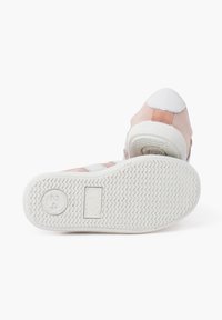 Suede and textile sneaker in pink with white accents. Features a textured rubber sole and rear tab. Smooth and patterned design elements.