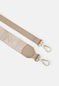 Cinghia beige con una texture liscia, caratterizzata da un logo prominente, clip in metallo dorato e dettagli di cucitura su entrambe le estremità.