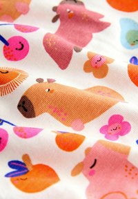 Tissu à motifs avec des animaux de dessin animé comprenant un capybara de couleur beige, un oiseau rose, un fruit orange et des fleurs souriantes sur un fond blanc.