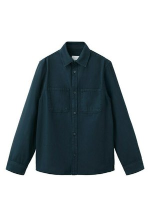 Chemise à manches longues bleu foncé avec boutons, col et deux poches poitrine, présentée à plat sur un fond blanc.