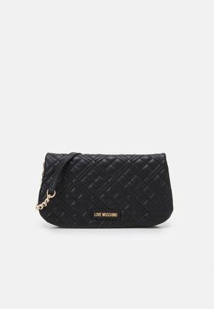 Sort quiltet læder Love Moschino clutch med guldkæde-rem og logo-plakette foran mod ensfarvet baggrund.
