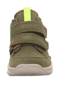 Dětské tenisky olivově zelené barvy s dvěma suchými zipy, světle béžovou podrážkou a jasně žlutým poutkem na jazyku.