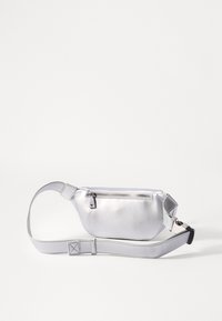 Srebrna metalna torbica za pas z gladko teksturo, z zadrgo in nastavljivim trakom, opremljena s stransko sprostitveno sponko.
