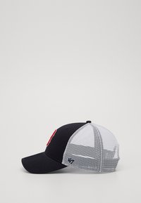 Black and white baseball cap with mesh back, featuring a red logo on the front and adjustable strap for fit.
