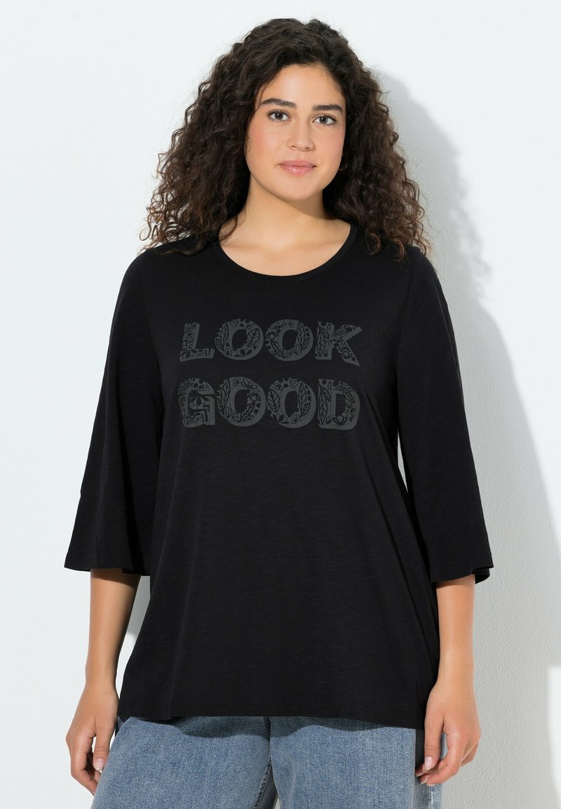 Czarny t-shirt z rękawami za łokieć, z napisem "LOOK GOOD" ozdobionym dekoracyjną czcionką. Miękka tkanina, luźne dopasowanie.