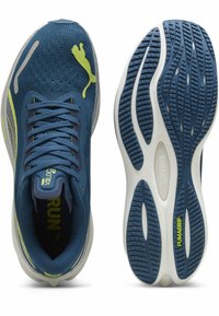 Scarpe da ginnastica blu con tomaia in rete, dettagli gialli e suole in gomma testurizzata con un motivo a onde e tecnologia di presa.