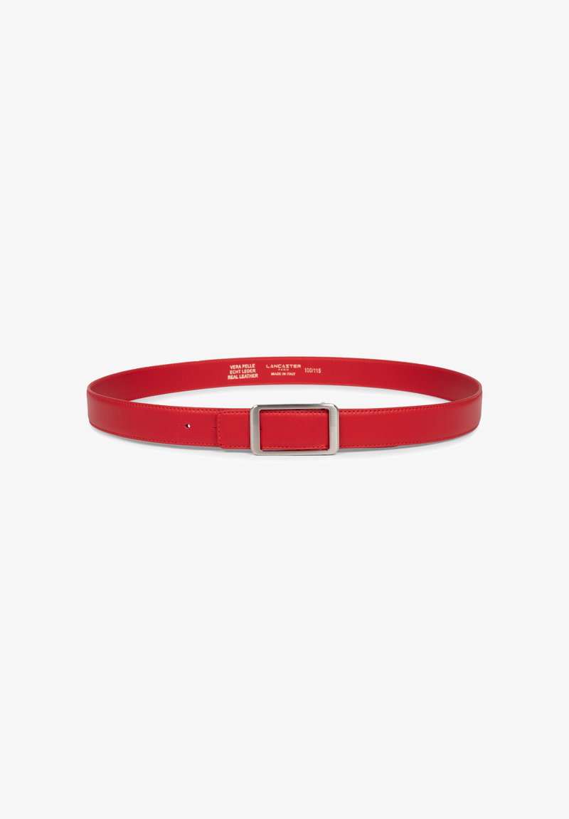 Ceinture en cuir rouge avec une boucle rectangulaire en argent, non attachée, posée à plat sur un fond blanc, marquages de taille visibles à l'intérieur.