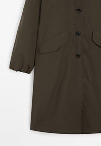 Trench coat verde oliva realizzato in tessuto strutturato, con chiusura a bottoni, due tasche frontali e polsini elasticizzati.