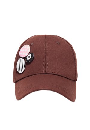 Casquette de baseball marron avec trois pins décoratifs : motif pied-de-poule rose, rayures noires et blanches, et un design de boule 8 noire.